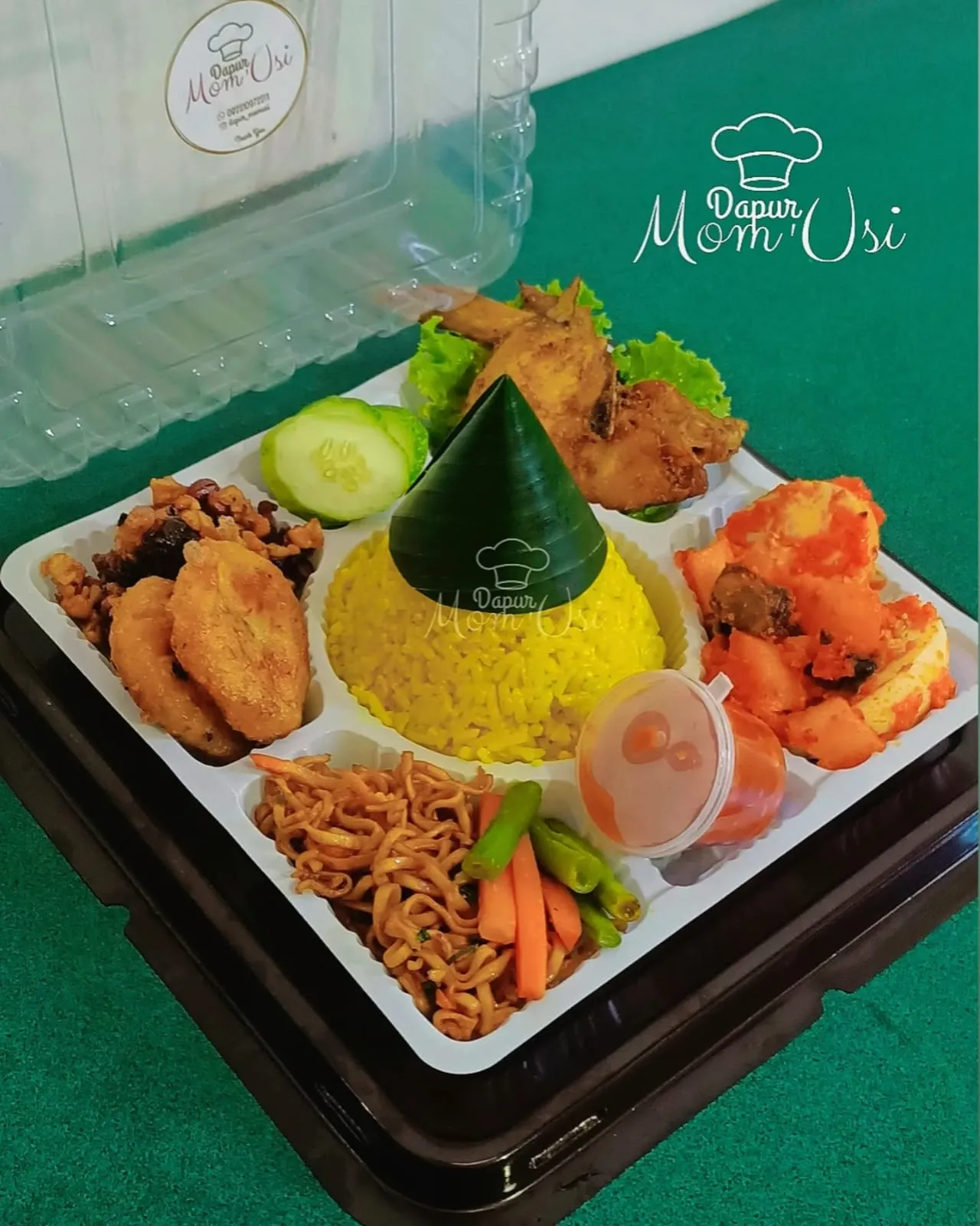 Tumpeng mini per pack dalam wadah sekat berisi nasi kuning kerucut, ayam goreng, mi goreng, dan sambal